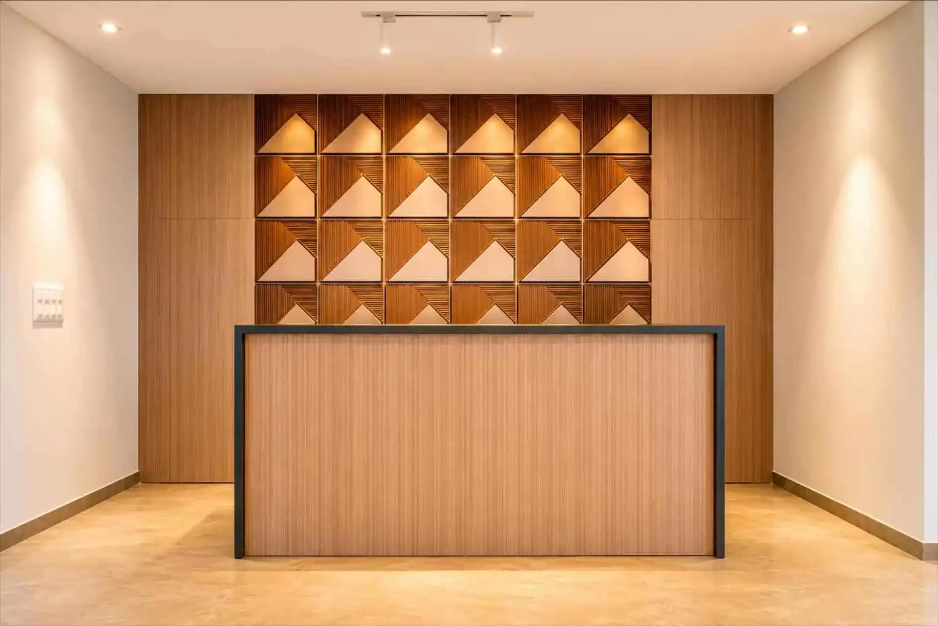 Reception desk with geometric mountain-motif tile feature wall
