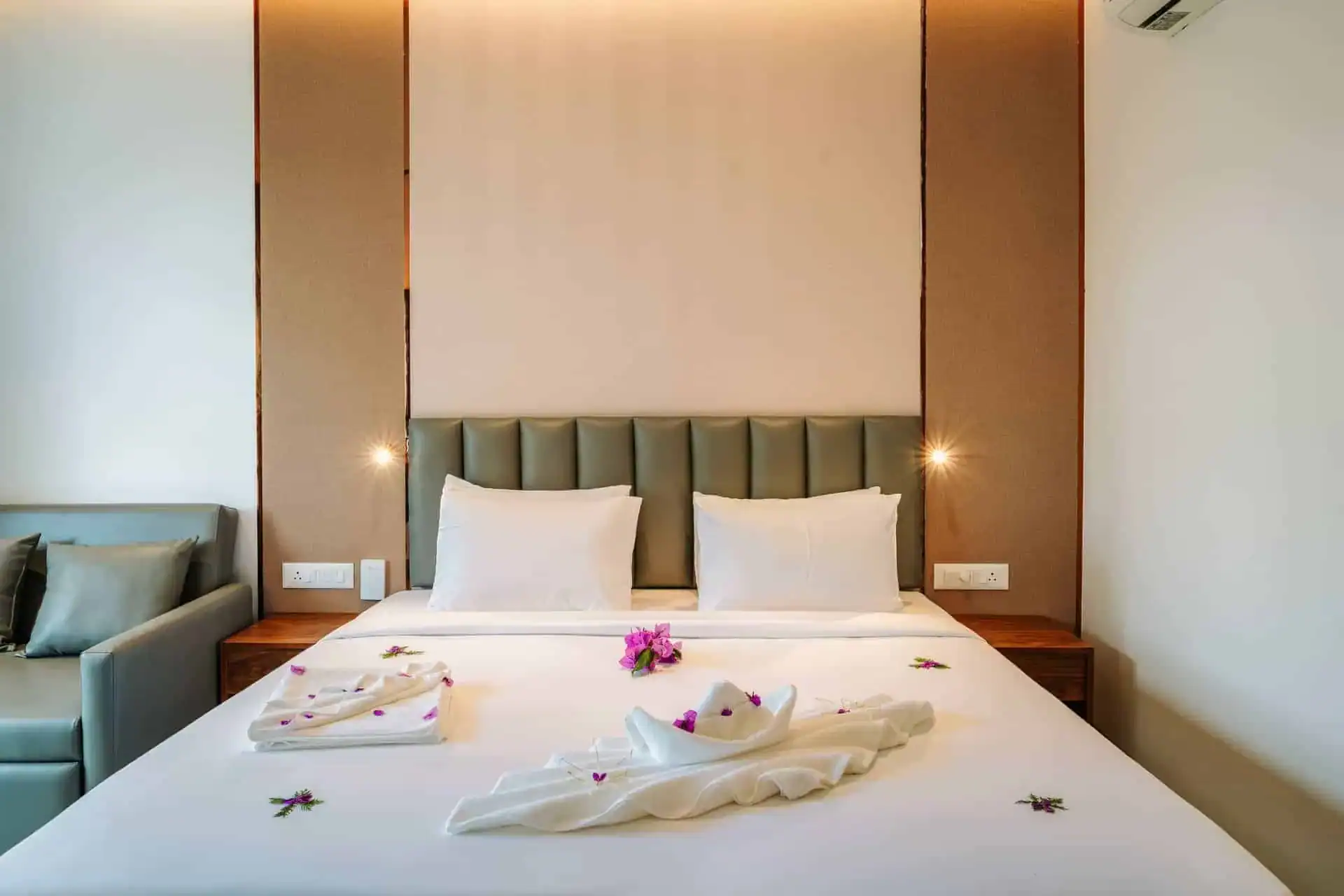 Romantic room detail with towel art and fresh purple flowers at Vega Munnar