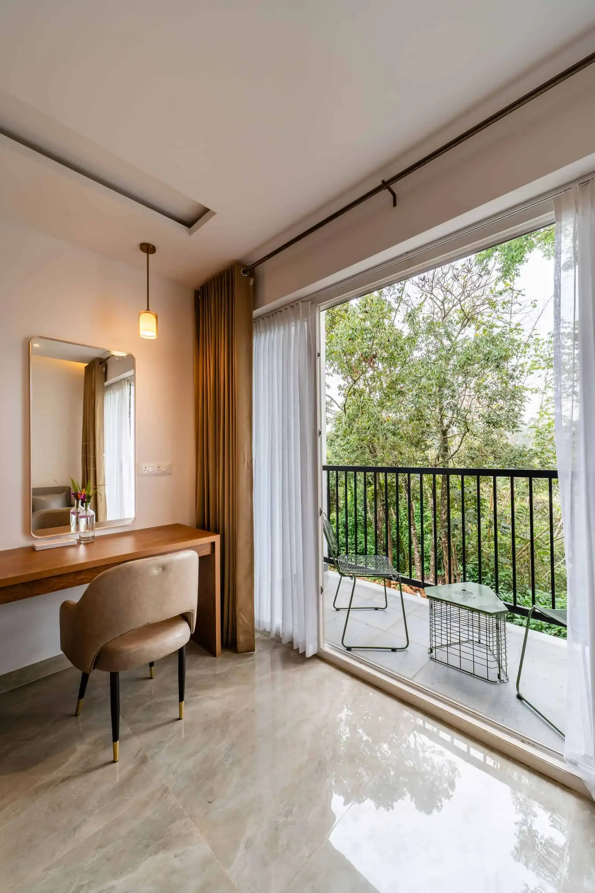 Dressing table with pendant light and bucket chair by the balcony